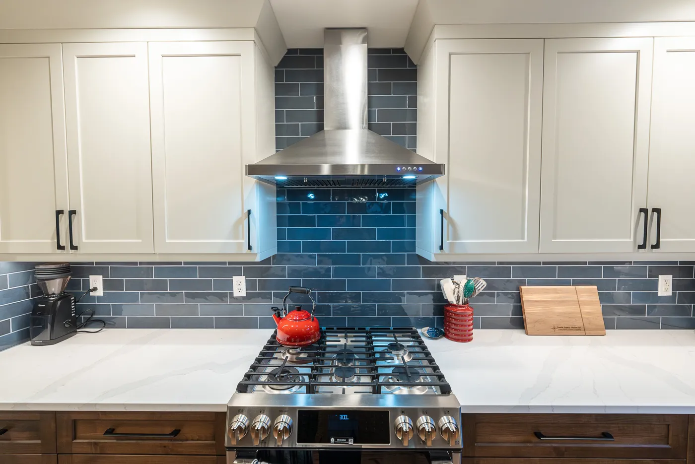 White shaker kitchen cabinets with a blue tile backsplash