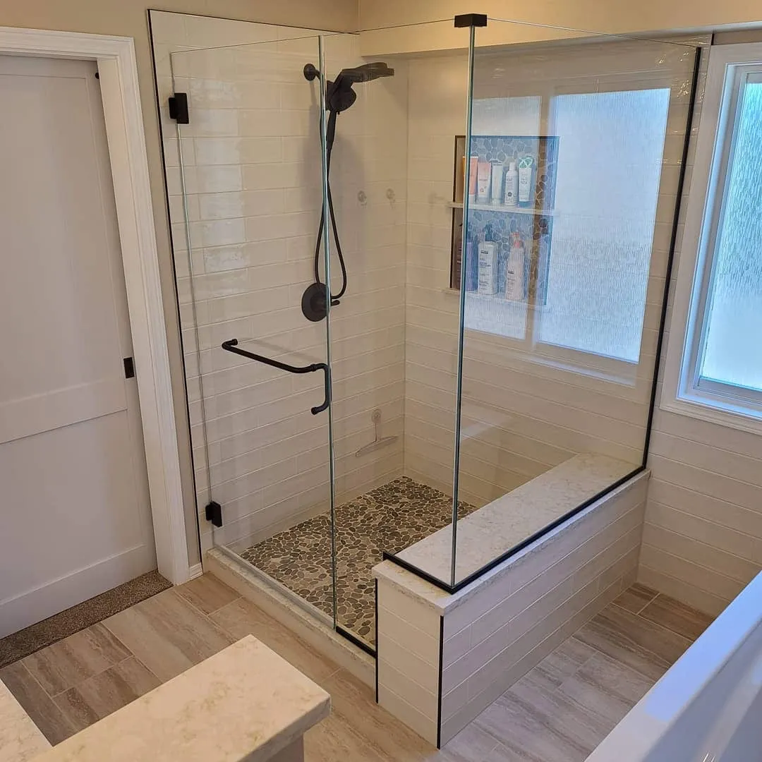 Walk-in glass shower with pebble tile floor